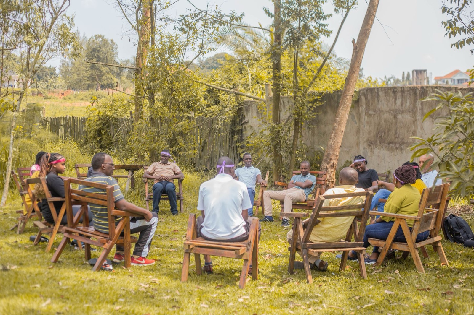 A community gathered in a circle of chairs outdoors